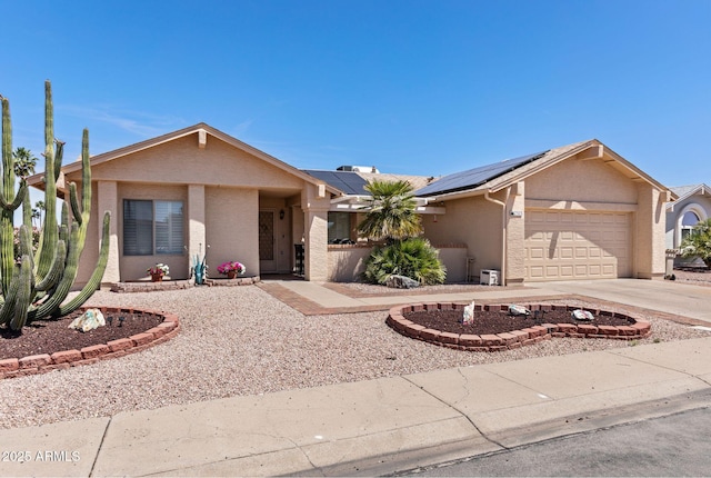 single story home with an attached garage, stucco siding, driveway, and solar panels