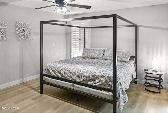 bedroom with baseboards, a ceiling fan, and wood finished floors