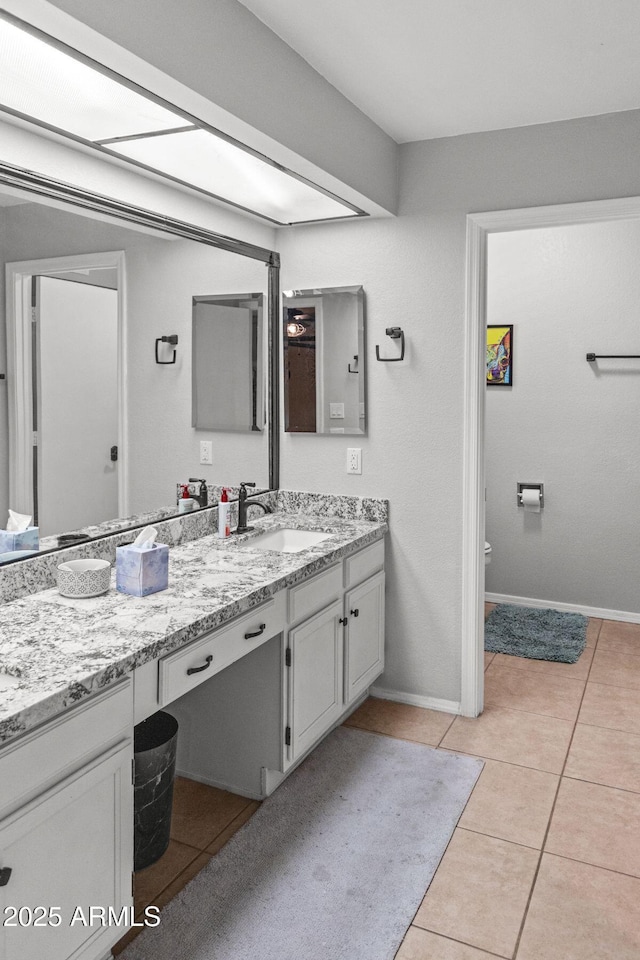 full bathroom with toilet, tile patterned floors, baseboards, and vanity