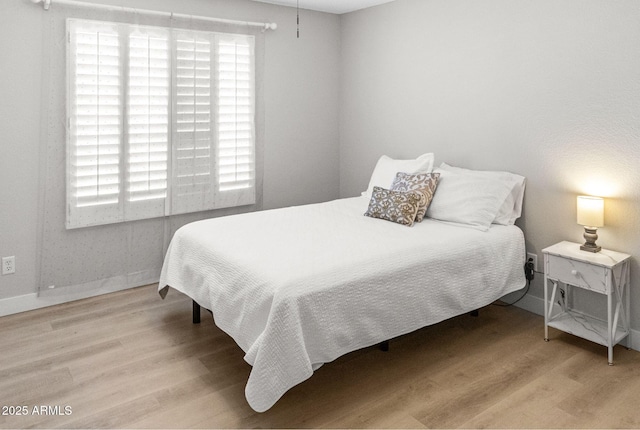 bedroom with baseboards and wood finished floors
