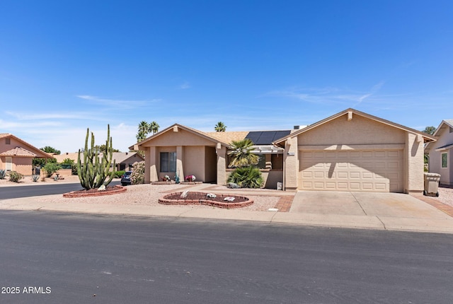 ranch-style home featuring an attached garage, driveway, roof mounted solar panels, and stucco siding