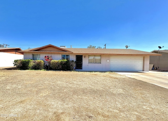 ranch-style house featuring a garage and driveway