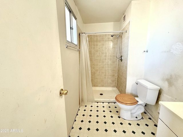 full bath with a stall shower, toilet, and vanity