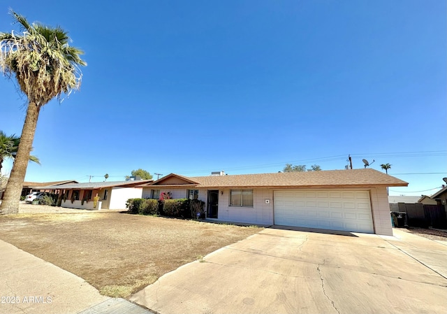 single story home featuring concrete driveway and an attached garage