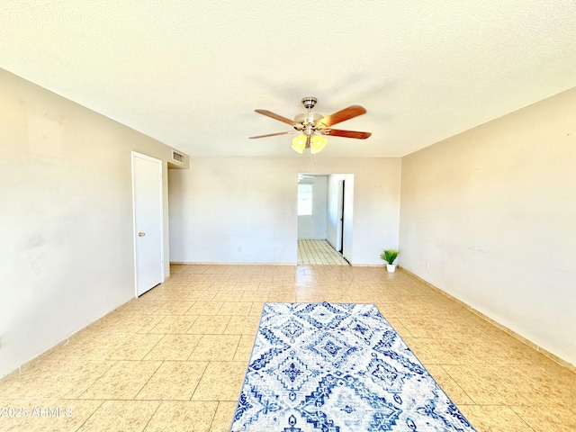 empty room featuring visible vents, a textured ceiling, and a ceiling fan