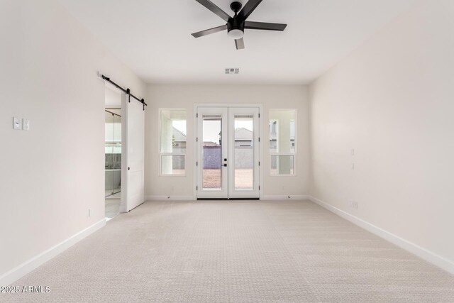 1645 E Minton St, Mesa, AZ 85203 - spare room featuring visible vents, baseboards, a barn door, ceiling fan, and light colored carpet