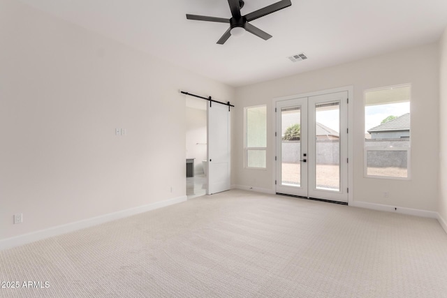1645 E Minton St, Mesa, AZ 85203 - unfurnished room with visible vents, baseboards, a barn door, a ceiling fan, and light colored carpet
