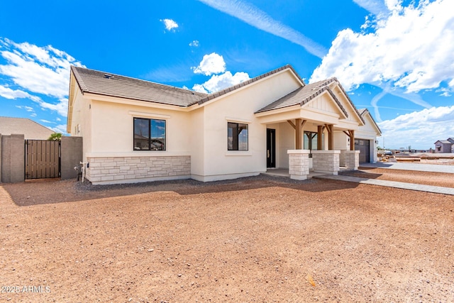 1645 E Minton St, Mesa, AZ 85203 - view of front of home featuring stone siding, a garage, a tile roof, concrete driveway, and a gate