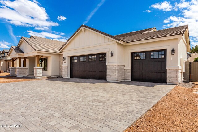 1645 E Minton St, Mesa, AZ 85203 - view of front of house with an attached garage, stone siding, a tile roof, and decorative driveway