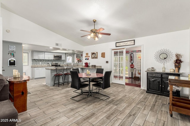 4013 E Delta Cir, Mesa, AZ 85206 - dining room featuring vaulted ceiling, ceiling fan, light wood finished floors, and plenty of natural light