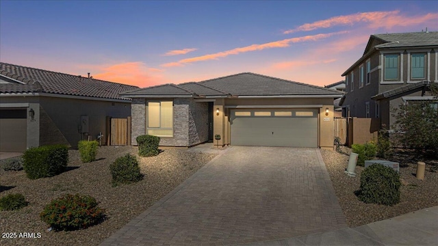 6313 N 68th Dr, Glendale, AZ 85303 - view of front facade featuring decorative driveway, a garage, stucco siding, a tiled roof, and fence