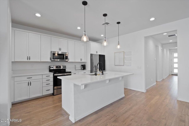 6313 N 68th Dr, Glendale, AZ 85303 - kitchen featuring appliances with stainless steel finishes, a sink, white cabinets, light wood-style floors, and recessed lighting