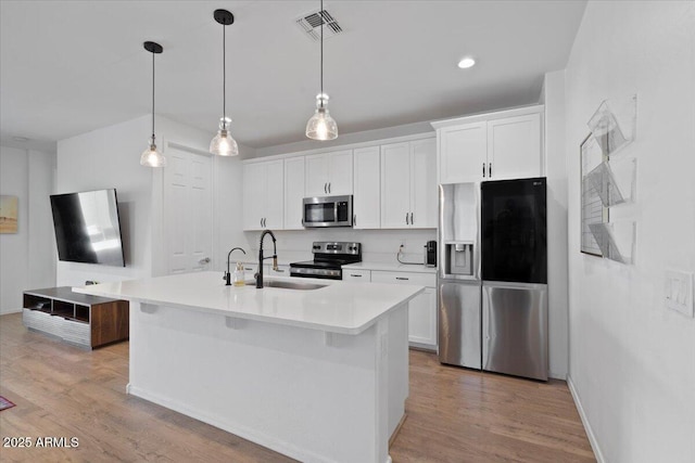 6313 N 68th Dr, Glendale, AZ 85303 - kitchen featuring appliances with stainless steel finishes, a sink, a center island with sink, white cabinetry, and recessed lighting