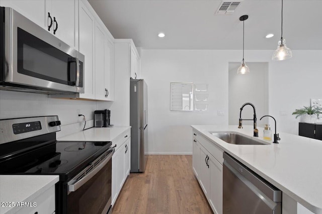 6313 N 68th Dr, Glendale, AZ 85303 - kitchen with appliances with stainless steel finishes, a sink, recessed lighting, white cabinets, and light wood-style floors