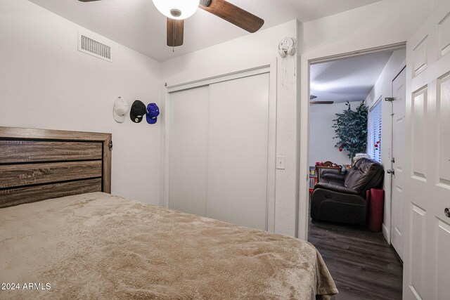 bedroom with a closet, dark hardwood / wood-style floors, and ceiling fan