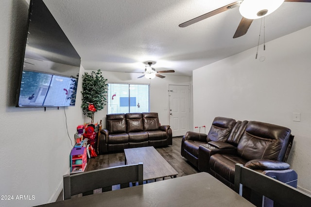 living area with baseboards, ceiling fan, a textured ceiling, and wood finished floors