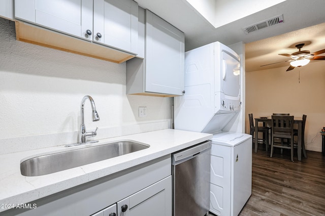 kitchen featuring dark hardwood / wood-style flooring, light stone countertops, dishwasher, sink, and stacked washer and clothes dryer