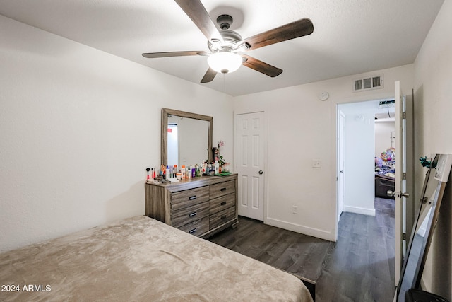 bedroom with dark hardwood / wood-style flooring, bar area, and ceiling fan