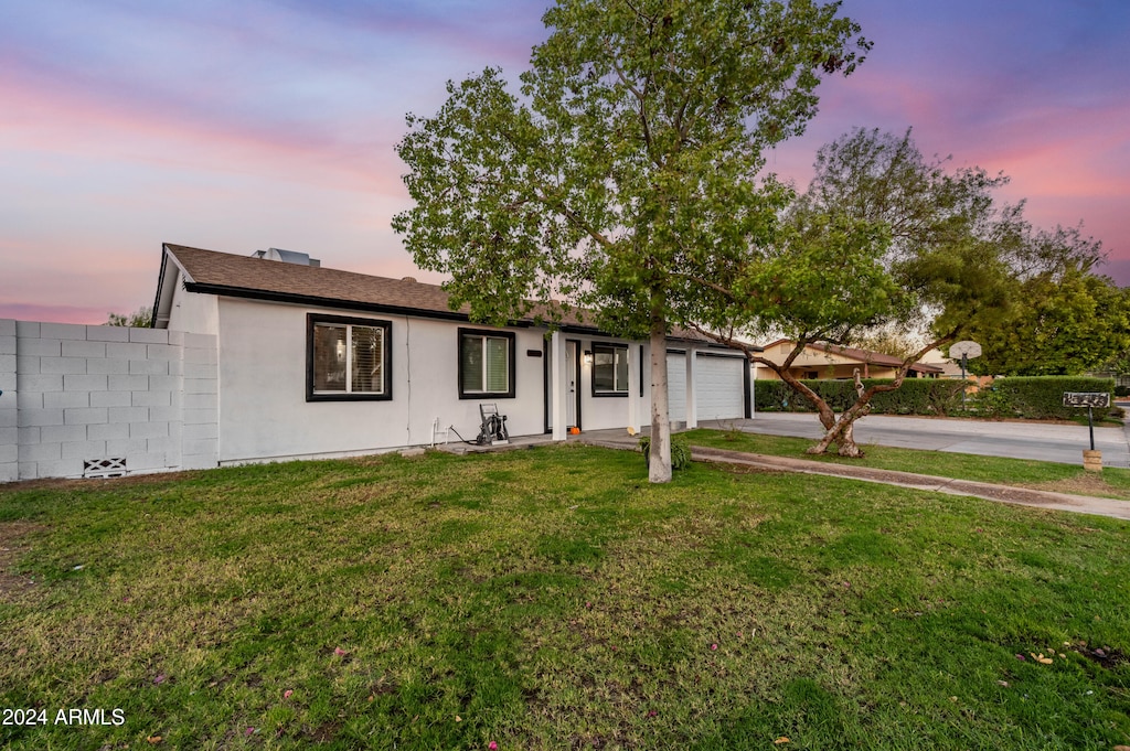 ranch-style home with a yard and a garage