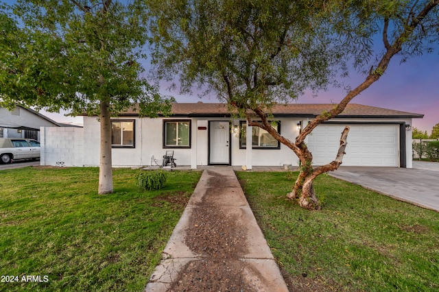 ranch-style home with a yard and a garage