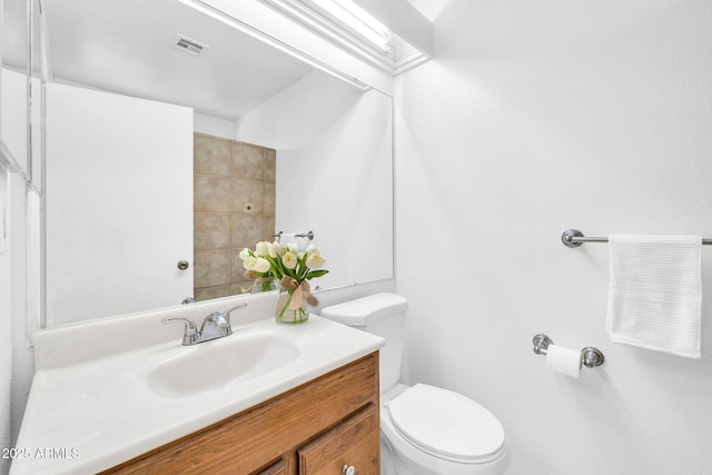 bathroom with vanity, toilet, and visible vents