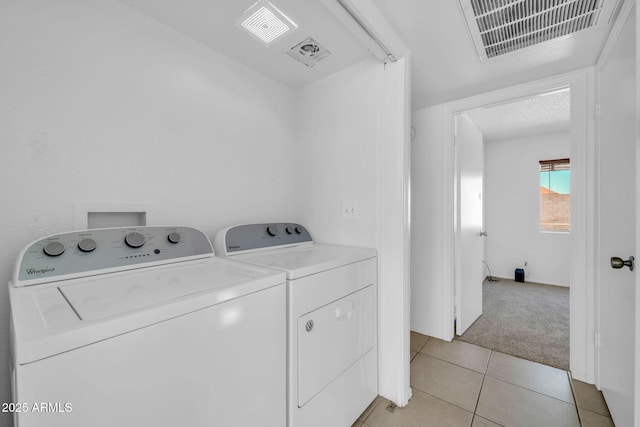 laundry area with independent washer and dryer, light tile patterned flooring, laundry area, light carpet, and visible vents