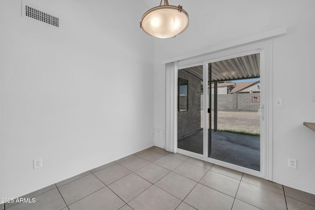 spare room with tile patterned floors, baseboards, and visible vents