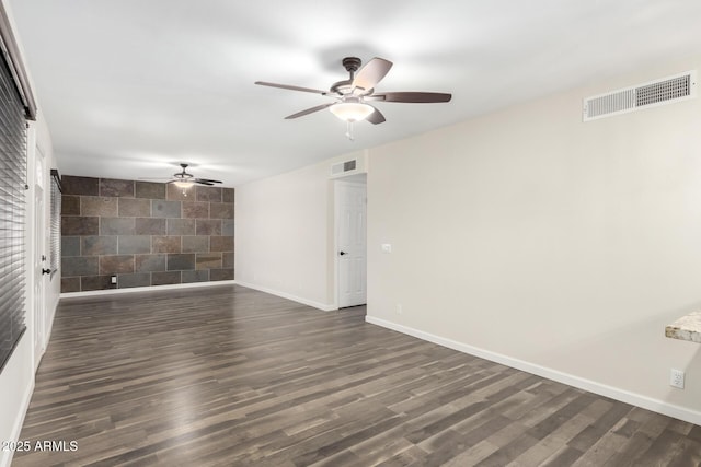 unfurnished room with dark wood-type flooring, baseboards, and visible vents