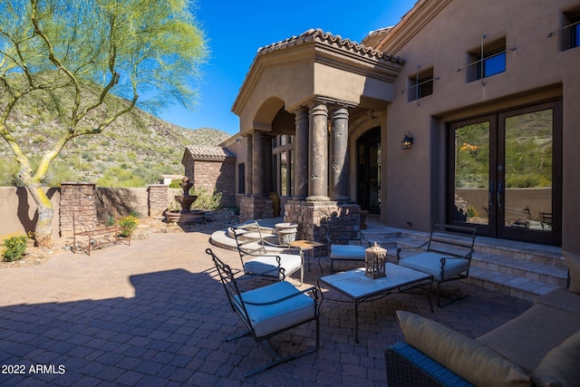 view of patio with a mountain view and french doors