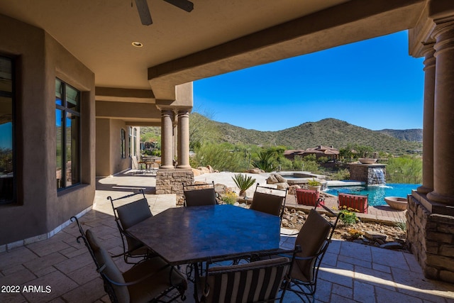 view of patio with a mountain view, a swimming pool with hot tub, pool water feature, and ceiling fan