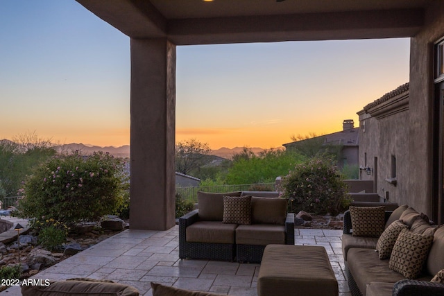 patio terrace at dusk featuring an outdoor living space and a mountain view