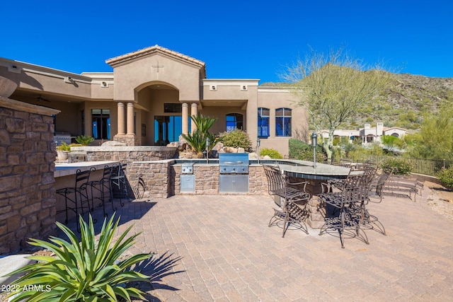 view of patio with exterior bar and area for grilling