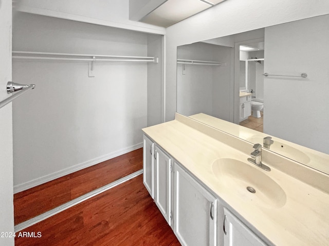 bathroom featuring hardwood / wood-style floors, vanity, a shower with shower door, and toilet