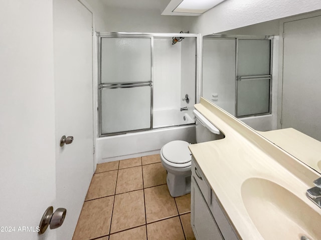 full bathroom with tile patterned flooring, vanity, toilet, and bath / shower combo with glass door