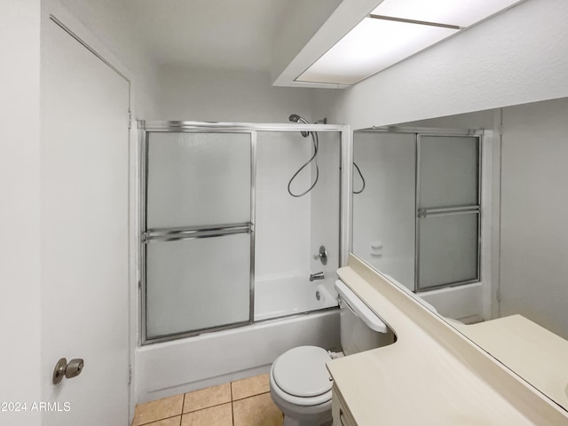 full bathroom featuring toilet, vanity, tile patterned floors, and enclosed tub / shower combo