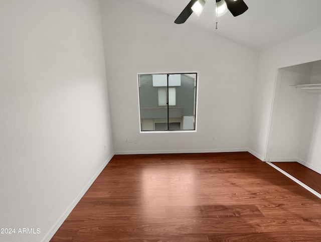 unfurnished bedroom featuring hardwood / wood-style floors, ceiling fan, vaulted ceiling, and a closet