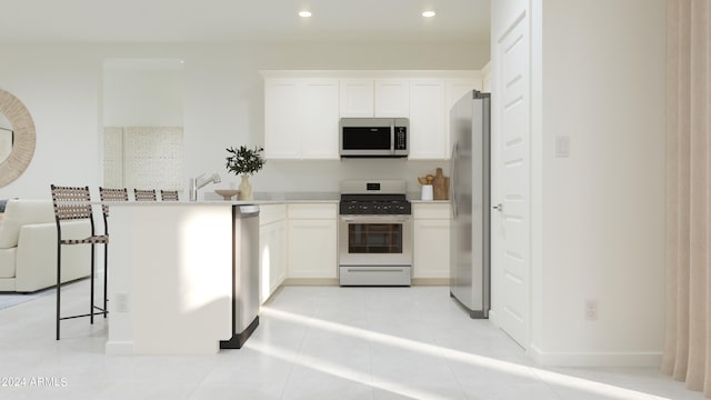 kitchen featuring light tile patterned floors, recessed lighting, stainless steel appliances, light countertops, and white cabinets