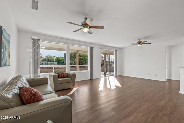 living room featuring dark wood-type flooring and ceiling fan