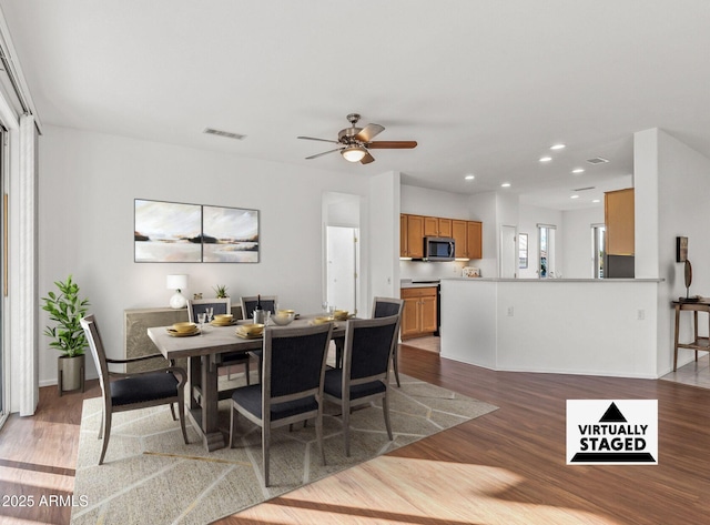 dining area with ceiling fan and light wood-type flooring