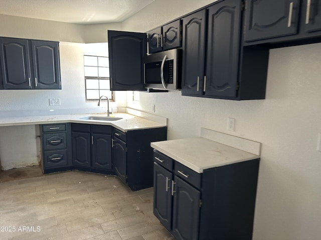 121 N Brown Ave, Casa Grande, AZ 85122 - kitchen with stainless steel microwave, light wood finished floors, light countertops, and a textured wall