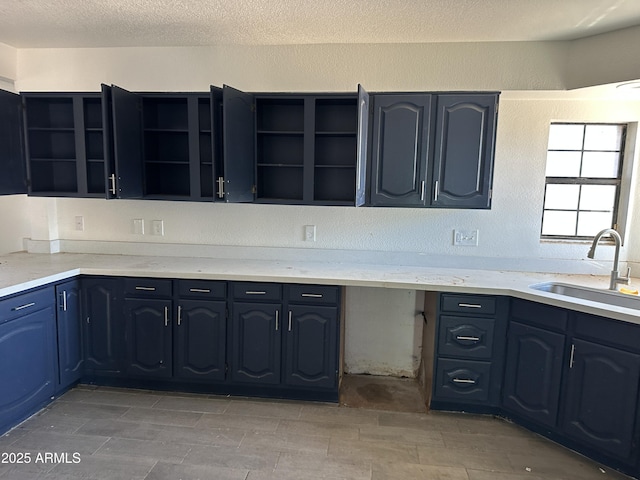 121 N Brown Ave, Casa Grande, AZ 85122 - kitchen with open shelves, a textured ceiling, light stone countertops, and blue cabinetry