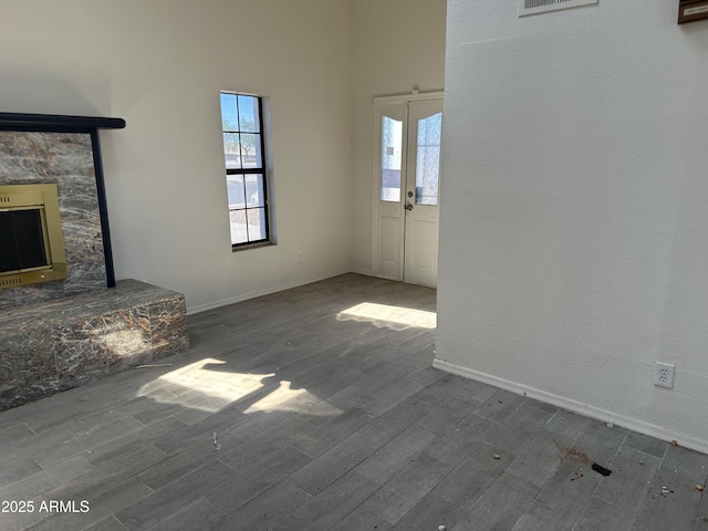 121 N Brown Ave, Casa Grande, AZ 85122 - unfurnished living room with wood finished floors, a fireplace, and a towering ceiling