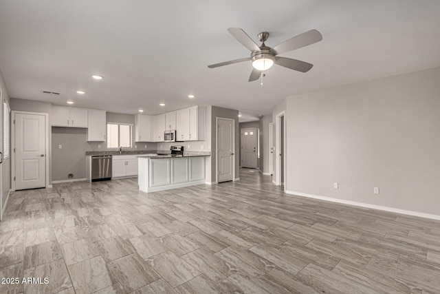 unfurnished living room with sink and ceiling fan