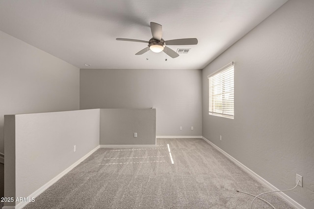 spare room with ceiling fan and light carpet