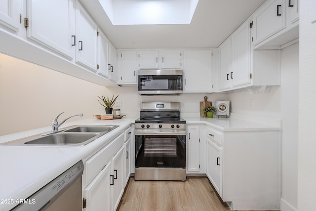 kitchen featuring white cabinetry, light hardwood / wood-style flooring, sink, and appliances with stainless steel finishes