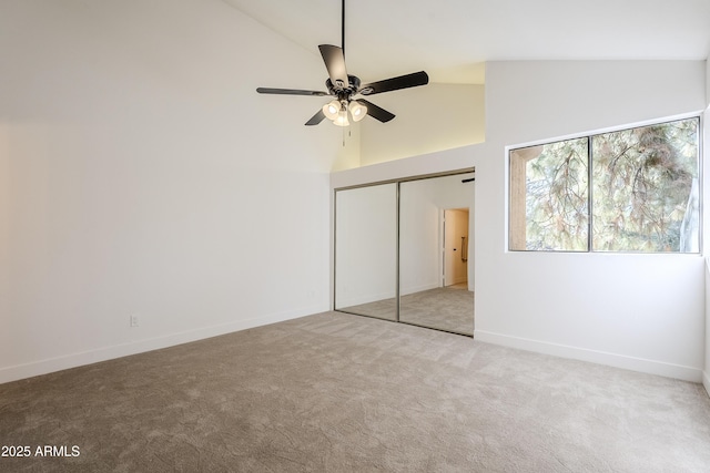 unfurnished bedroom with carpet floors, ceiling fan, a closet, and high vaulted ceiling