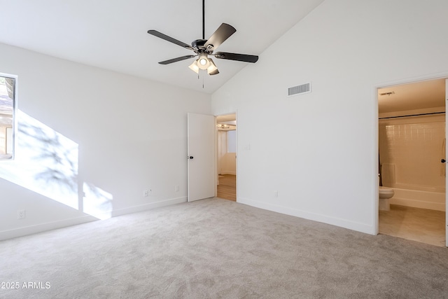 unfurnished bedroom featuring carpet flooring, high vaulted ceiling, ensuite bath, and ceiling fan