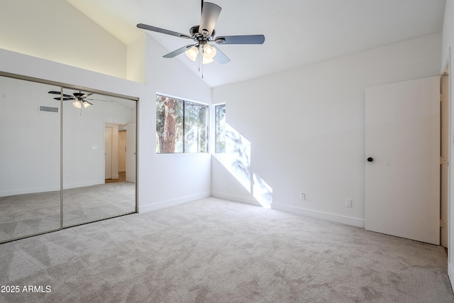 unfurnished bedroom featuring light colored carpet, high vaulted ceiling, a closet, and ceiling fan