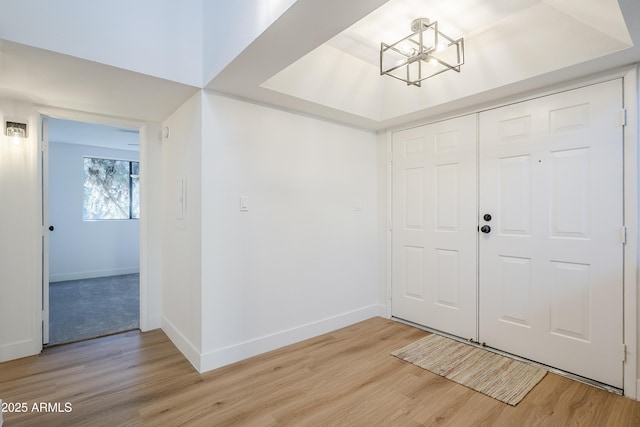 foyer entrance with a chandelier and light hardwood / wood-style floors