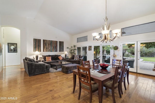 dining space featuring french doors, a chandelier, and light wood-type flooring